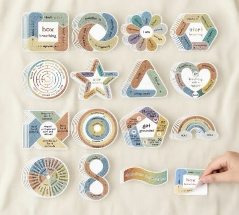 Set of colorful mindfulness cards stickers on a beige surface with a hand holding one card.