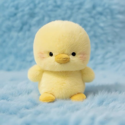 Yellow plush duck toy on a blue textured background