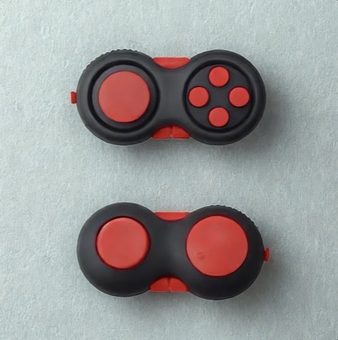 Two red and black fidget spinners on a light gray background
