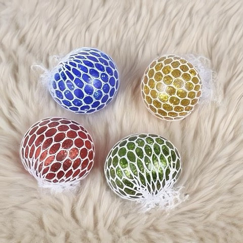 Four colorful textured balls on a fluffy white surface
