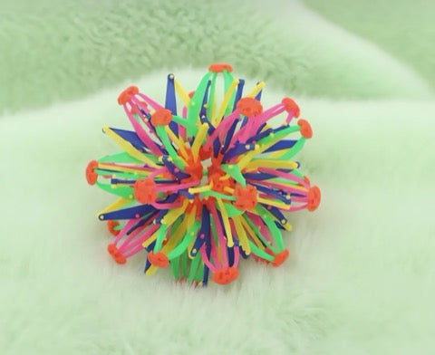 Colorful rubber band ball on a light green background